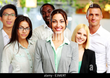 Felice gruppo di collaboratori in piedi in ufficio Foto Stock