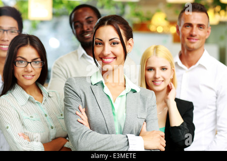 Felice gruppo di collaboratori in piedi in ufficio Foto Stock