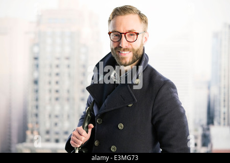 Ritratto di imprenditore sorridente nella finestra urbana Foto Stock