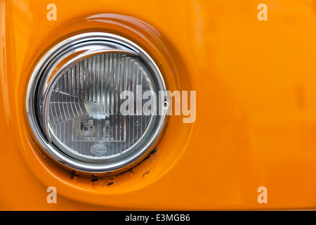 Orizzontale di close-up di VW Volkswagen T2 caravan lato sinistro faro sul cofano arancione Foto Stock