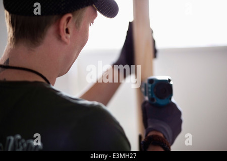 Vista posteriore del carpentiere lavorando presso il sito Foto Stock