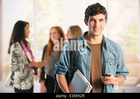 Ritratto di studente di college per la messaggistica di testo con un telefono cellulare Foto Stock