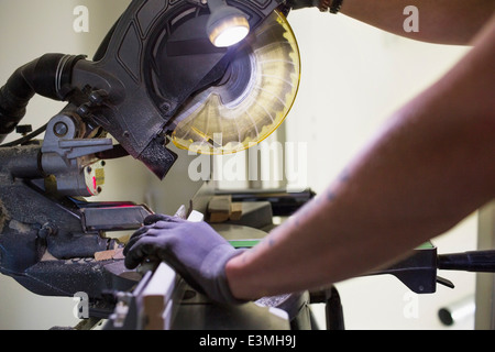 Lavoratore edile con sega elettrica presso il sito Foto Stock