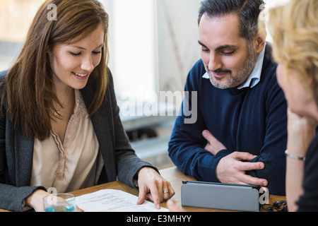 Multi-etnico imprenditori discutendo su documento alla scrivania in ufficio Foto Stock