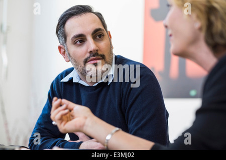 Imprenditore ascolto al collega di sesso femminile in riunione in ufficio Foto Stock