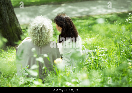 Vista posteriore femmina senior amici seduti in posizione di parcheggio Foto Stock