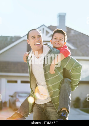 Padre piggybacking figlio Foto Stock