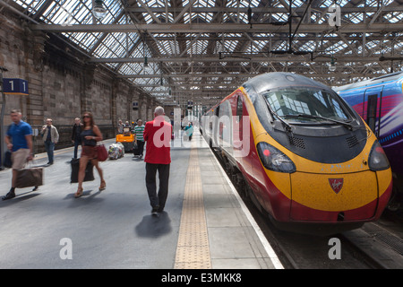 Treni del Virgin Pendolino 390130 (città di Edimburgo) con lo sbarco di passeggeri la Stazione Centrale di Glasgow, Glasgow, Scotland Regno Unito Foto Stock