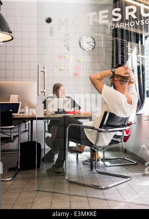 Young business persone sedute in ufficio creativo Foto Stock