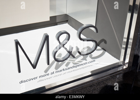 Sole brillante sul Marks & Spencer logo aziendale su un negozio di vetro fusione anteriore un'ombra nelle vetrine area di visualizzazione Foto Stock