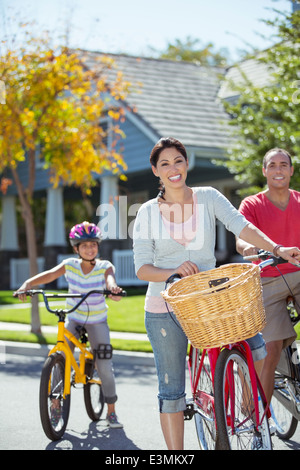 Ritratto di famiglia felice con le biciclette in strada Foto Stock