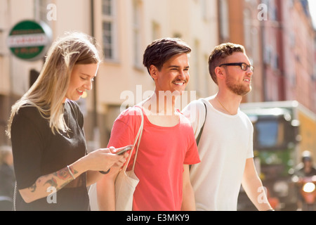 Felice giovani amici a camminare su una strada di città Foto Stock