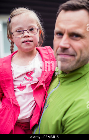 Ritratto di una ragazza con la sindrome di down portato dal padre Foto Stock