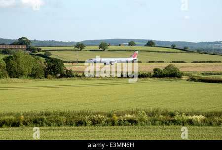 Aeroporto di Exeter Devon England Regno Unito visto attraverso i terreni agricoli a A321 Airbus Fly Niki sulla pista Foto Stock