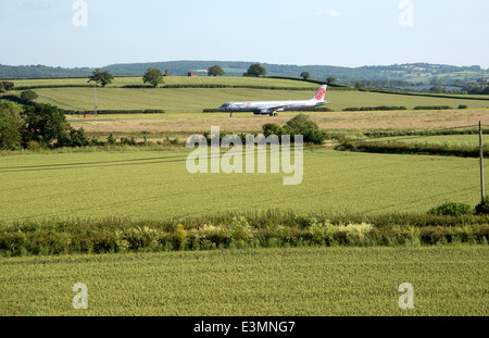 Aeroporto di Exeter Devon England Regno Unito visto attraverso i terreni agricoli a A321 Airbus Fly Niki sulla pista Foto Stock