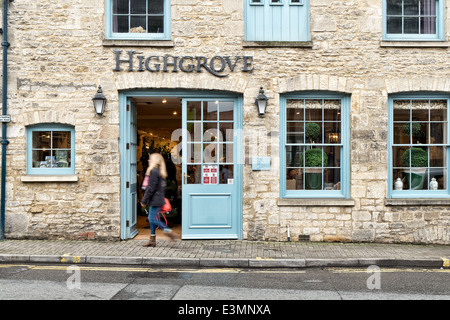 Una donna, movimento sfocati passeggiate passato lo sportello anteriore del principe Charles's Highgrove store nel Cotswold città di Tetbury Foto Stock