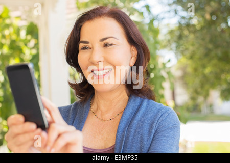 La donna per la messaggistica di testo con un telefono cellulare Foto Stock