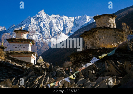 Stupa e una parete di mani nel villaggio di SAMAGAUN sul intorno il MANASLU TREK - REGIONE NUPRI, NEPAL Foto Stock