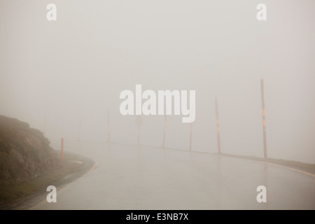 Svuotare strada coperta di nebbia contro il cielo chiaro Foto Stock