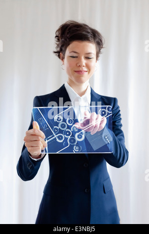 Ritratto di sorridere imprenditrice utilizzando il futuristico tavoletta digitale Foto Stock