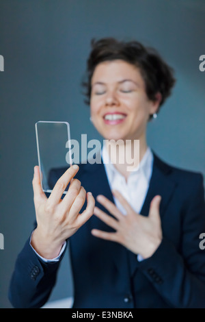 Soddisfatto imprenditrice Azienda Blank futuristico Smartphone trasparente Foto Stock