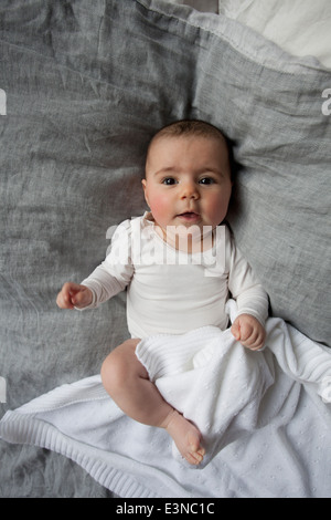 A piena lunghezza Ritratto di simpatici baby girl giacente a letto Foto Stock