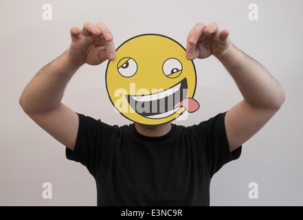 Uomo con un divertente di emoticon nella faccia anteriore del suo volto Foto Stock