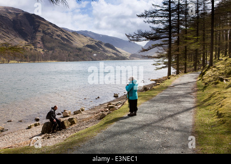 Regno Unito, Cumbria, Lake District, Buttermere, escursionisti in appoggio sul sentiero lungolago attraverso Burtness legno Foto Stock