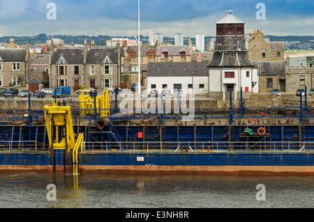 Nave Dragaggio del canale di entrata al porto di Aberdeen Scotland CON IL VECCHIO ROUNDHOUSE IN BACKGROUND Foto Stock