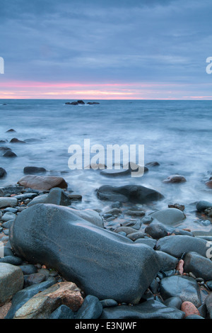 Tramonto sul mare roccioso riva Guernsey Foto Stock