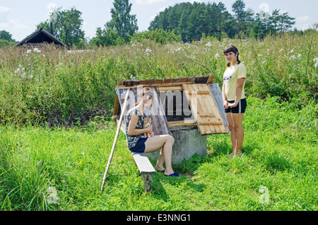 Rural Lifestyle estate 2013. Gli abitanti del villaggio - ragazze e rosso-arancione cat vicino a un bene. Foto Stock