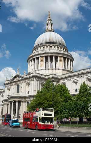 Un open top double deck tour bus passa la cattedrale di St Paul in una giornata di sole Foto Stock
