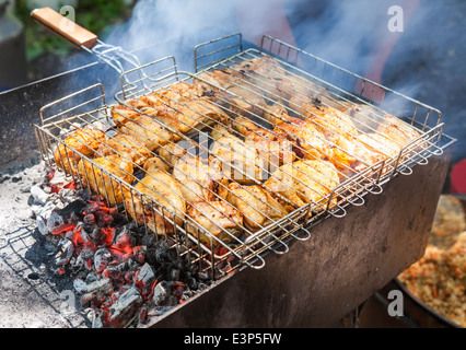 Preparazione di pollo fette di carne in salsa sul fuoco Foto Stock
