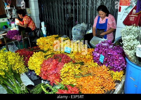 BANGKOK, Thailandia: Donna presso la sua bancarella vendendo multi-colore di orchidee a Bangkok il mercato dei fiori Foto Stock