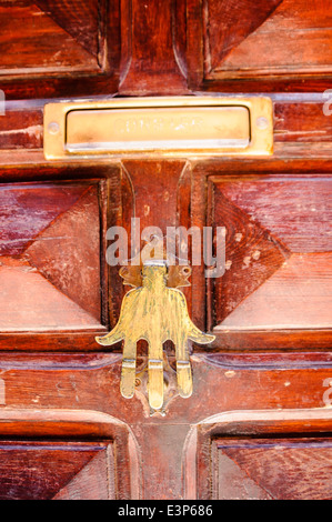 Porta in ottone respingente e letter box su di un legno scuro porta a spiovente. Foto Stock