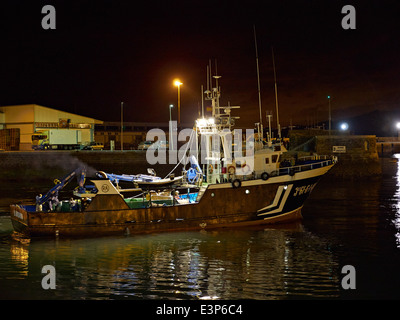 Getaria, Gipuzkoa, Paesi Baschi, Spagna. La trafficata commerciale porto di pesca. Un peschereccio si prepara a lasciare il porto di notte. Foto Stock