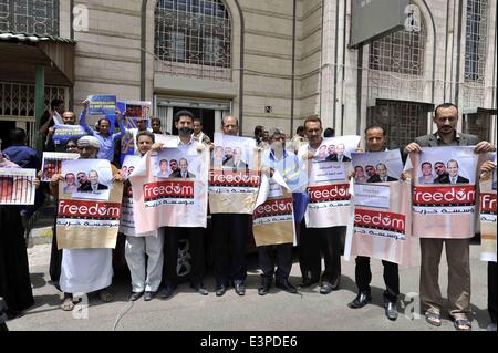 Sanaa, Yemen. Il 25 giugno, 2014. Giornalisti yemenita tenere i poster e le foto di tre giornalisti che sono state condannate alla prigione da un giudice egiziano durante un prostest in Sanaa, Yemen, Giugno 25, 2014. Un tribunale egiziano condannato tre Al Jazeera giornalisti in carcere nel corso degli oneri di aiutare la messa fuorilegge Fratellanza Musulmana lunedì. © Mohammed Mohammed/Xinhua/Alamy Live News Foto Stock