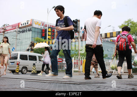 (140626) -- Pechino, 26 giugno 2014 (Xinhua) -- i pedoni a piedi attraverso la linea ferroviaria su Wudaokou nel Distretto Haidian di Pechino, capitale della Cina, 13 giugno 2014. Wudaokou, letteralmente in cinese il quinto passaggio a livello dell'Beijing-Baotou Raiwaly, è un quartiere del Distretto Haidian del nord ovest di Pechino. In prossimità di un gran numero di università e noto per la sua grande numero di studenti internazionali, Wudaokou ha un altro nome 'Universo Center' circolanti tra gli studenti universitari. La vecchia Università Tsinghua stazione ferroviaria, che era stato costruito nel 1910 su Wudaokou come una stazione sulla Beijin Foto Stock