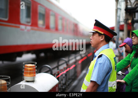 (140626) -- Pechino, 26 giugno 2014 (Xinhua) -- un poliziotto ferroviario di attendere per il passaggio di un treno in corrispondenza di un incrocio a Wudaokou nel Distretto Haidian di Pechino, capitale della Cina, 13 giugno 2014. Wudaokou, letteralmente in cinese il quinto passaggio a livello dell'Beijing-Baotou Raiwaly, è un quartiere del Distretto Haidian del nord ovest di Pechino. In prossimità di un gran numero di università e noto per la sua grande numero di studenti internazionali, Wudaokou ha un altro nome 'Universo Center' circolanti tra gli studenti universitari. La vecchia Università Tsinghua stazione ferroviaria, che era stato costruito nel 1910 su Wudao Foto Stock