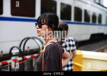 (140626) -- Pechino, 26 giugno 2014 (Xinhua) -- uno straniero attende per il passaggio di un treno su Wudaokou nel Distretto Haidian di Pechino, capitale della Cina, 13 giugno 2014. Wudaokou, letteralmente in cinese il quinto passaggio a livello dell'Beijing-Baotou Raiwaly, è un quartiere del Distretto Haidian del nord ovest di Pechino. In prossimità di un gran numero di università e noto per la sua grande numero di studenti internazionali, Wudaokou ha un altro nome 'Universo Center' circolanti tra gli studenti universitari. La vecchia Università Tsinghua stazione ferroviaria, che era stato costruito nel 1910 su Wudaokou come una stazione su t Foto Stock