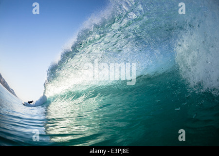 Surfer distante un surf Nuoto acqua foto closeup cava di onda oceanica travolgente Foto Stock