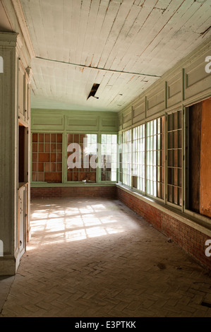 Pavimento in cotto nella vecchia veranda con intavolato windows, rotto la carenatura del soffitto e vernice incrinato Foto Stock