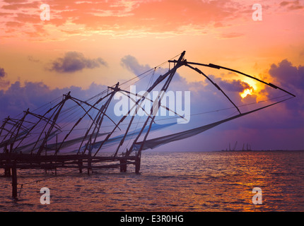 Vintage retrò hipster stile immagine di viaggio di Kochi fishnets cinese sul tramonto con texture grunge sovrapposto. Fort Kochin, India Foto Stock