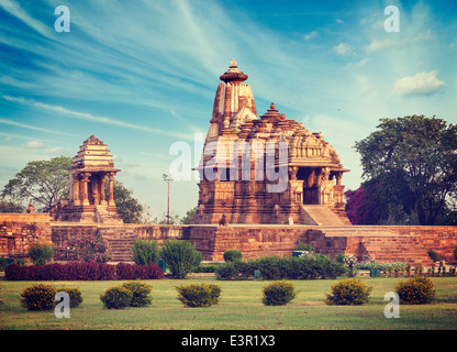 Vintage retrò hipster stile immagine di viaggio di Khajuraho Devi Jagdamba tempio e mahadev mandapa su sunrise. Khajuraho, India Foto Stock