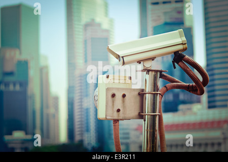 Vintage retrò hipster stile immagine di viaggio di sorveglianza TVCC telecamera in Singapore con grattacieli in background Foto Stock