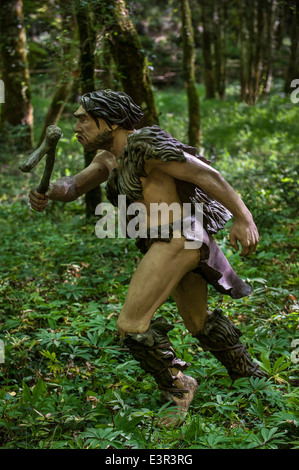 Il cacciatore di Neanderthal a caccia di prede nella foresta a Prehisto Parc, il parco a tema sulla vita preistorica a Tursac, Dordogne, Francia Foto Stock