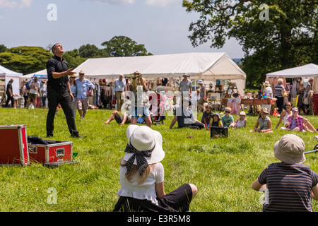 East Devon. Il 21 giugno 2014. Una Summer Party in giardino e Fete con un giocoliere intrattenere adulti e bambini con un gigante yoyo ect Foto Stock