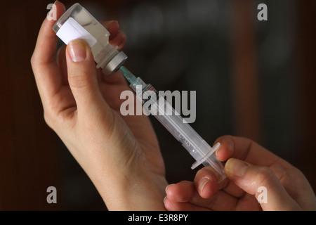 Una studentessa infermiera prassi influenza la procedura di vaccinazione in Montreal, Que. Foto Stock