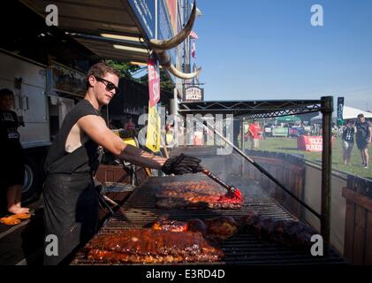 Toronto, Canada. Il 27 giugno, 2014. Un uomo aggiunge uno spesso strato di salsa barbecue al pollo durante il XV annuale Ribfest di Toronto a Toronto, Canada, 27 giugno 2014. Ha dato dei calci a fuori il venerdì, i cinque giorni di carne-amante di fesitival attirano decine di migliaia di persone. © Zou Zheng/Xinhua/Alamy Live News Foto Stock