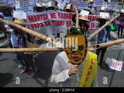 Manila, Filippine. Il 27 giugno, 2014. MANILA, Filippine - i dimostranti mockingly spinta germogli di bambù per un uomo che indossa il presidente filippino Aquino la maschera come agricoltori a partire dalla controversa zucchero station wagon Hacienda Luisita, come pure i manifestanti da differenti militante e gruppi di lavoro fase simultaneamente una protesta presso lo storico ponte Mendiola appena fuori dalle porte del Palazzo Presidenziale a Manila il 27 giugno 2014. Credito: ZUMA Press, Inc./Alamy Live News Foto Stock